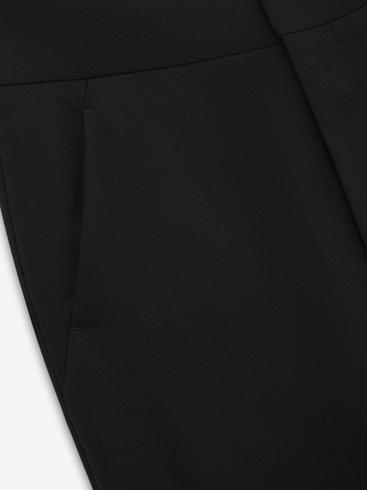 Double Weave Wool Flared Flat Front Pants close up in black showing the waistband angled pocket and smooth wool texture as Bottoms