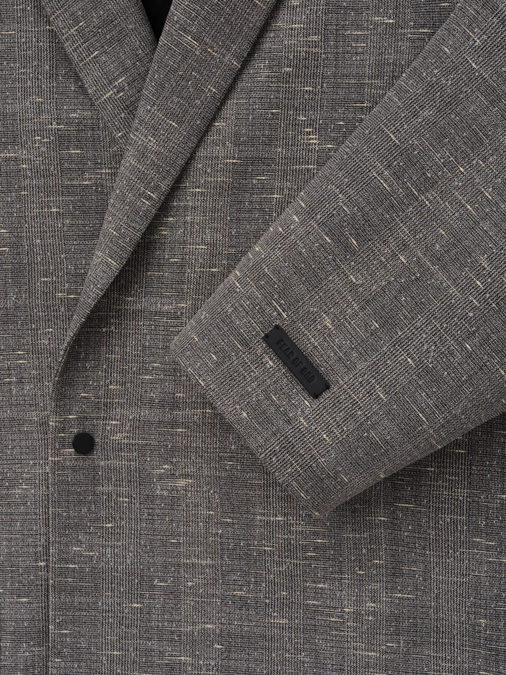Slub Wool Cotton Relaxed Jacket close up in textured gray showing the notched lapel black button sleeve cuff and woven fabric detail as Outerwear