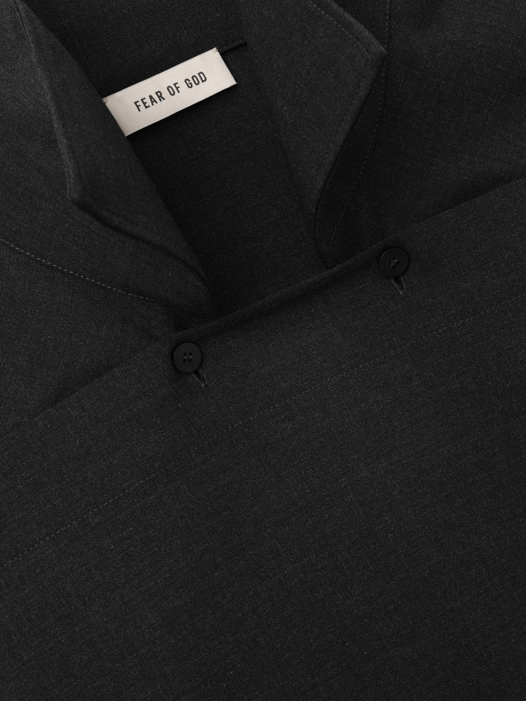 Melange Wool Pullover Shirt close up in black showing the overlapping neckline two button closure and Fear of God label with a refined wool texture as Tops