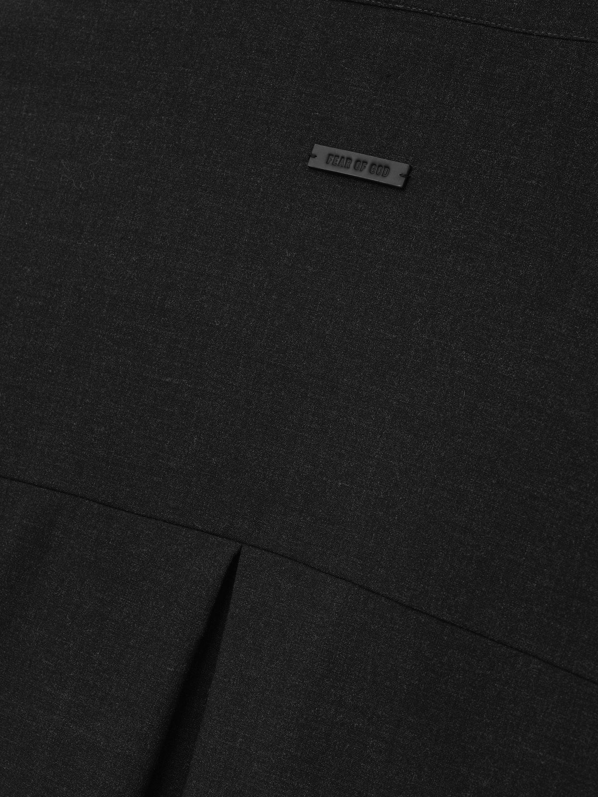 Melange Wool Pullover Shirt close up in black showing the Fear of God label fine wool texture and pleated seam detail as Tops