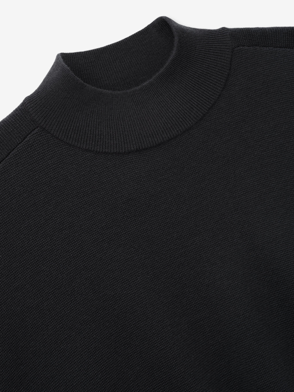 Merino Knit Mockneck Sweater close up in black showing its ribbed mock neckline and fine knit texture as Tops