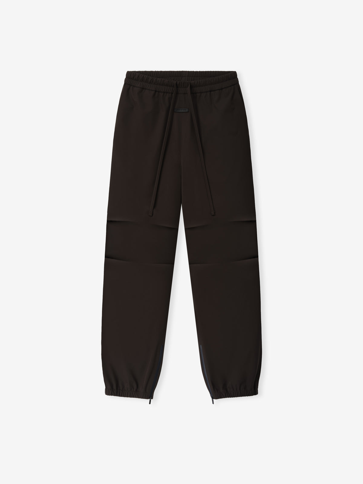 Bonded Nylon Track Pant shown flat in dark brown with an elastic drawstring waist, articulated knees, tapered legs, and zip ankle cuffs as Bottoms