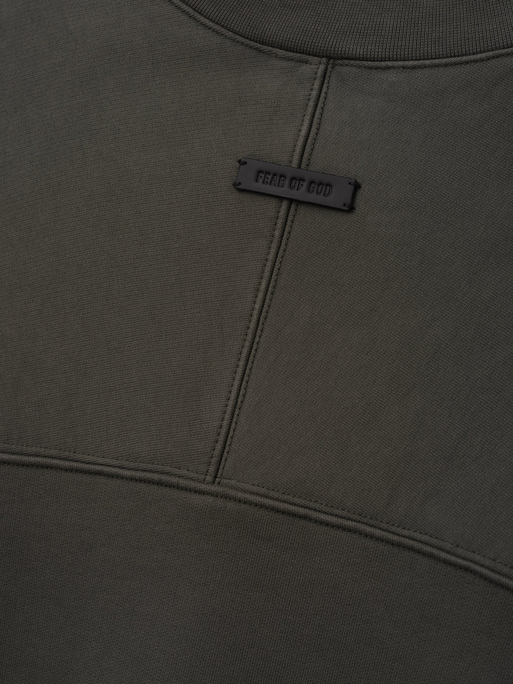 Fleece Crewneck in dark gray shown close up with a ribbed collar curved seam details and a small Fear of God label as Tops