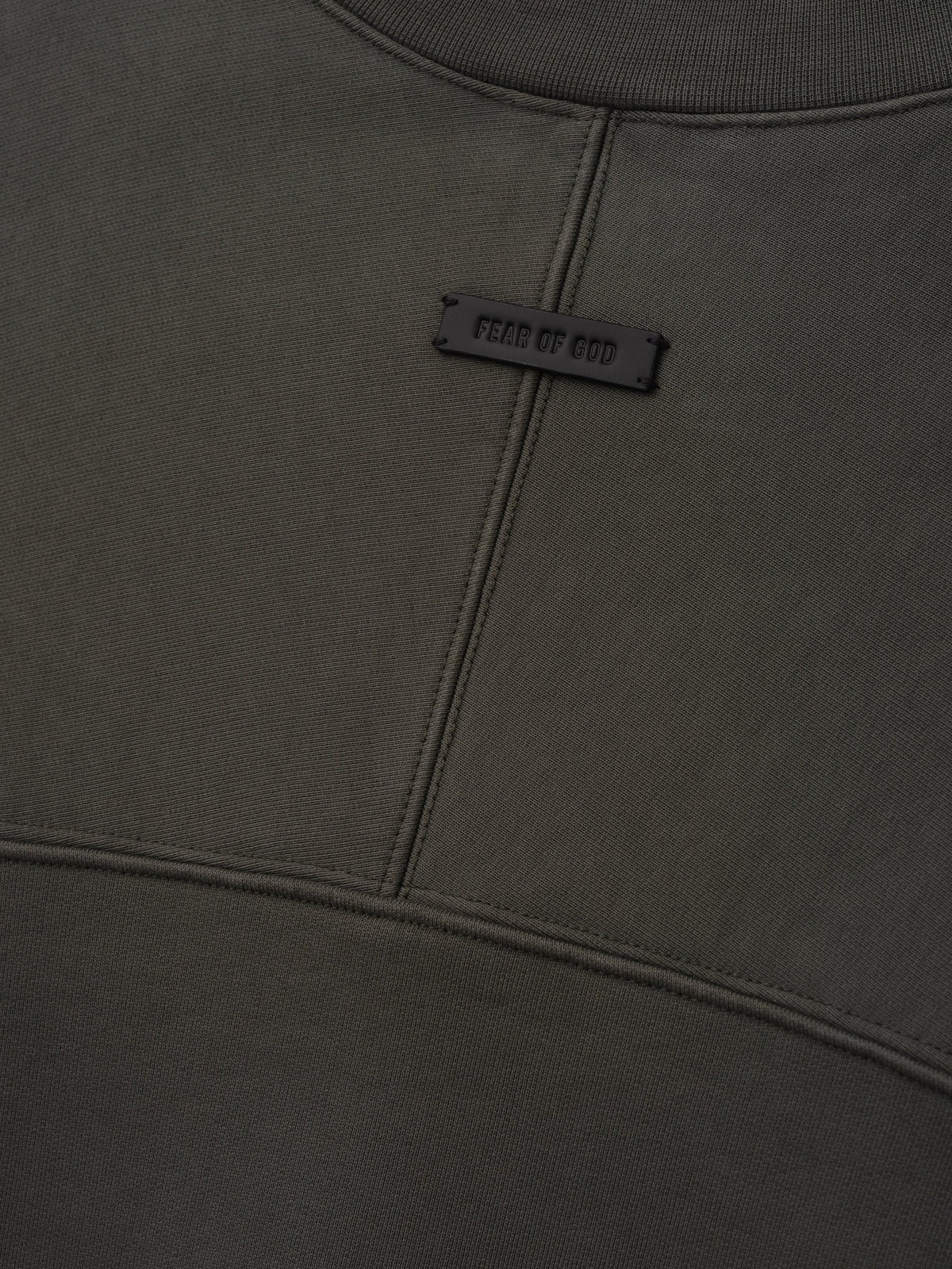 Fleece Crewneck in dark gray shown close up with a ribbed collar curved seam details and a small Fear of God label as Tops