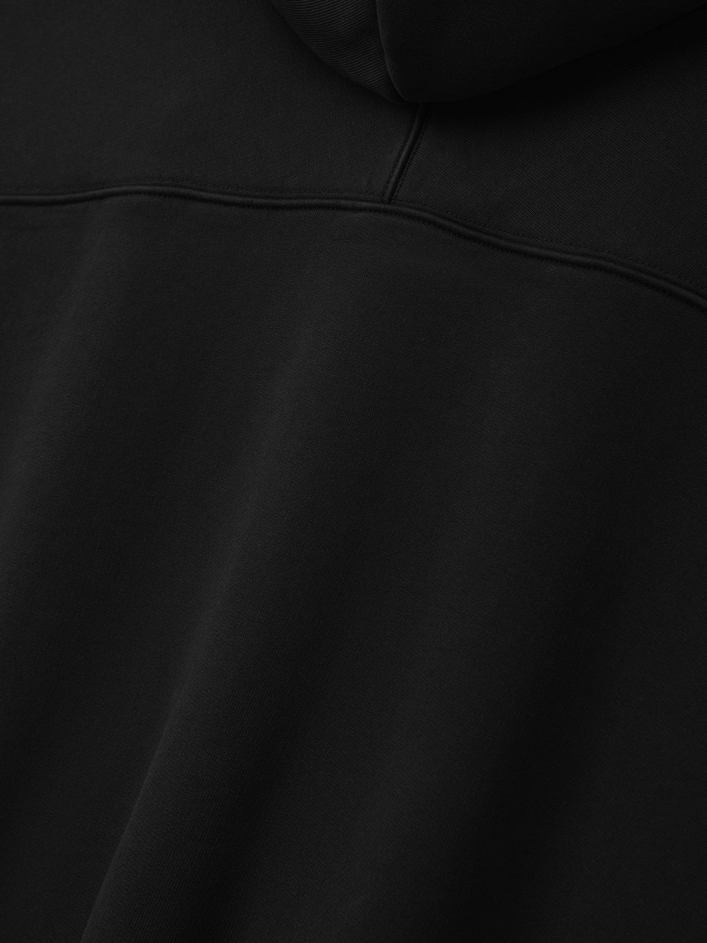 Raglan Full Zip Hoodie in black shown in close detail with a curved yoke seam and smooth fleece texture as Tops