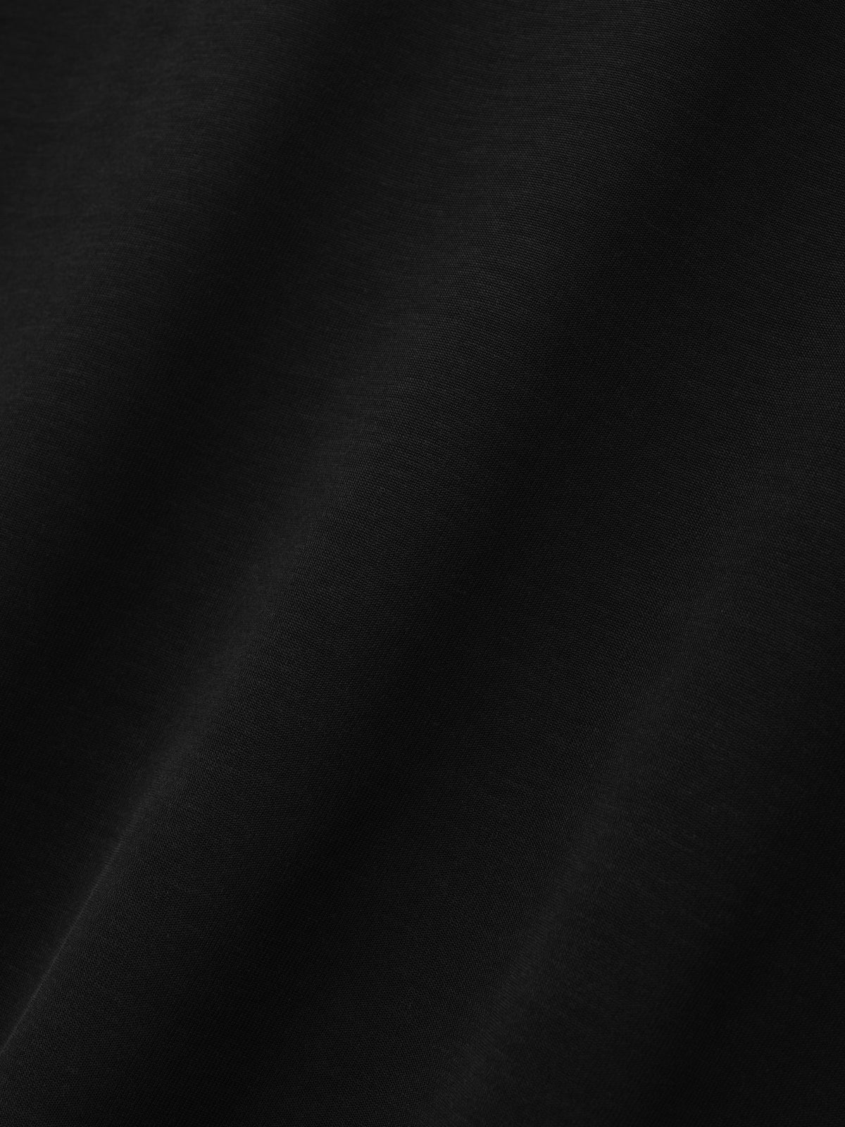 Cotton Rayon Mockneck Short Sleeve Tee in black shown in close detail with smooth cotton rayon fabric and subtle folds as Tops