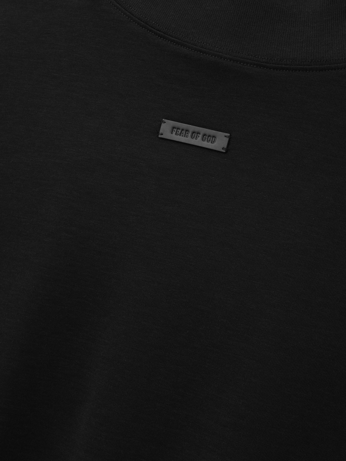 Cotton Rayon Mockneck Long Sleeve Tee in black shown in close detail with smooth fabric mockneck collar and Fear of God label as Tops