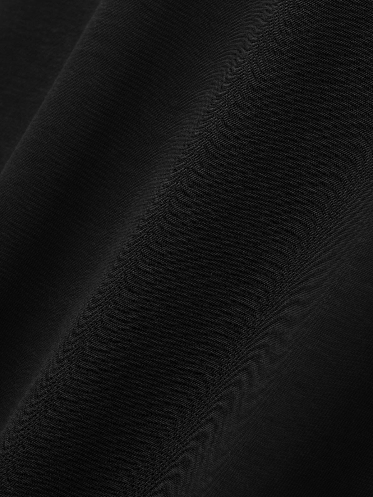 Cotton Rayon Eternal Tee in black shown in close detail with smooth cotton rayon fabric and subtle folds as Tops