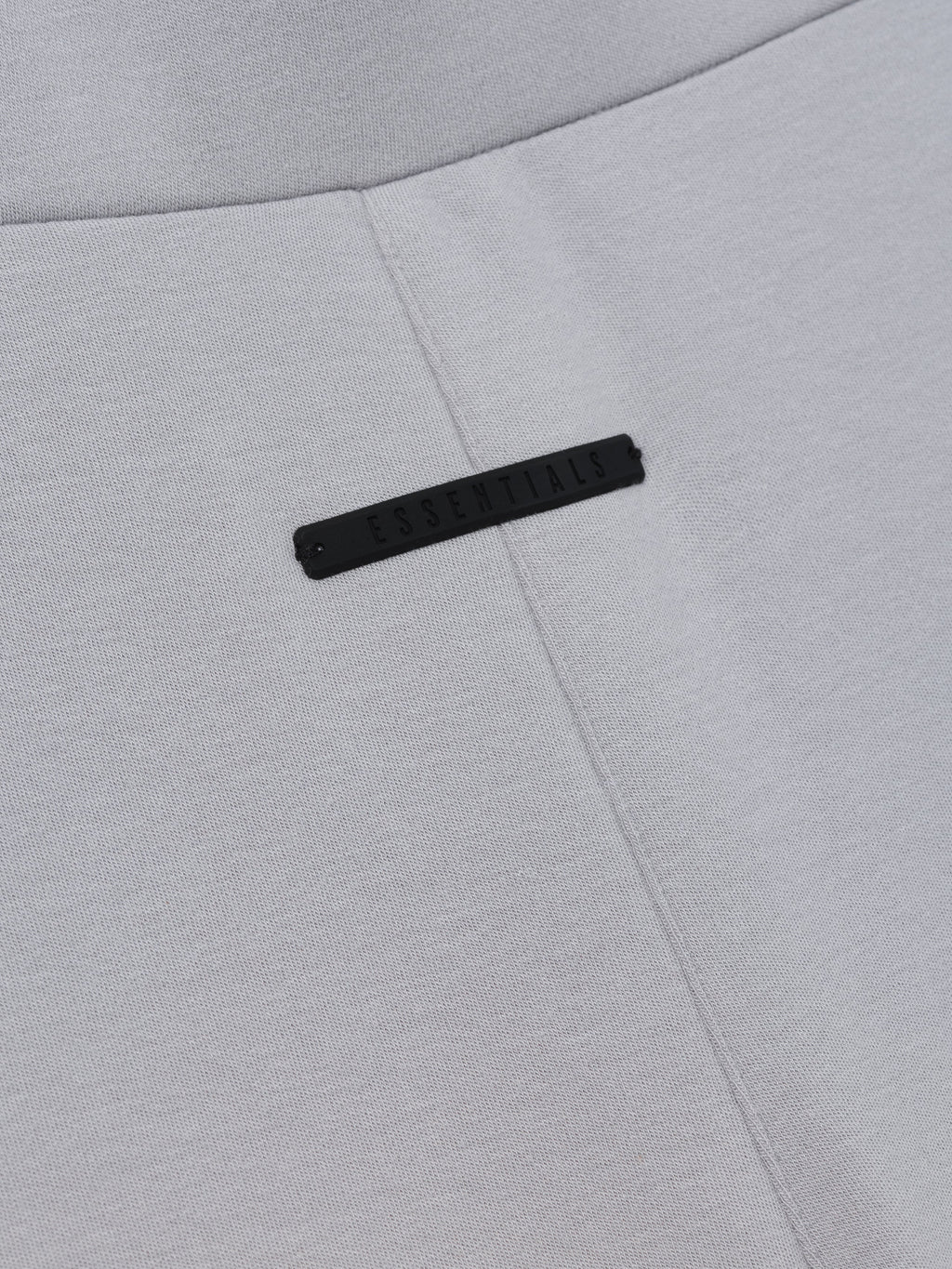 Womens Legging in light grey closeup showing a central seam and subtle black branding detail as Bottoms