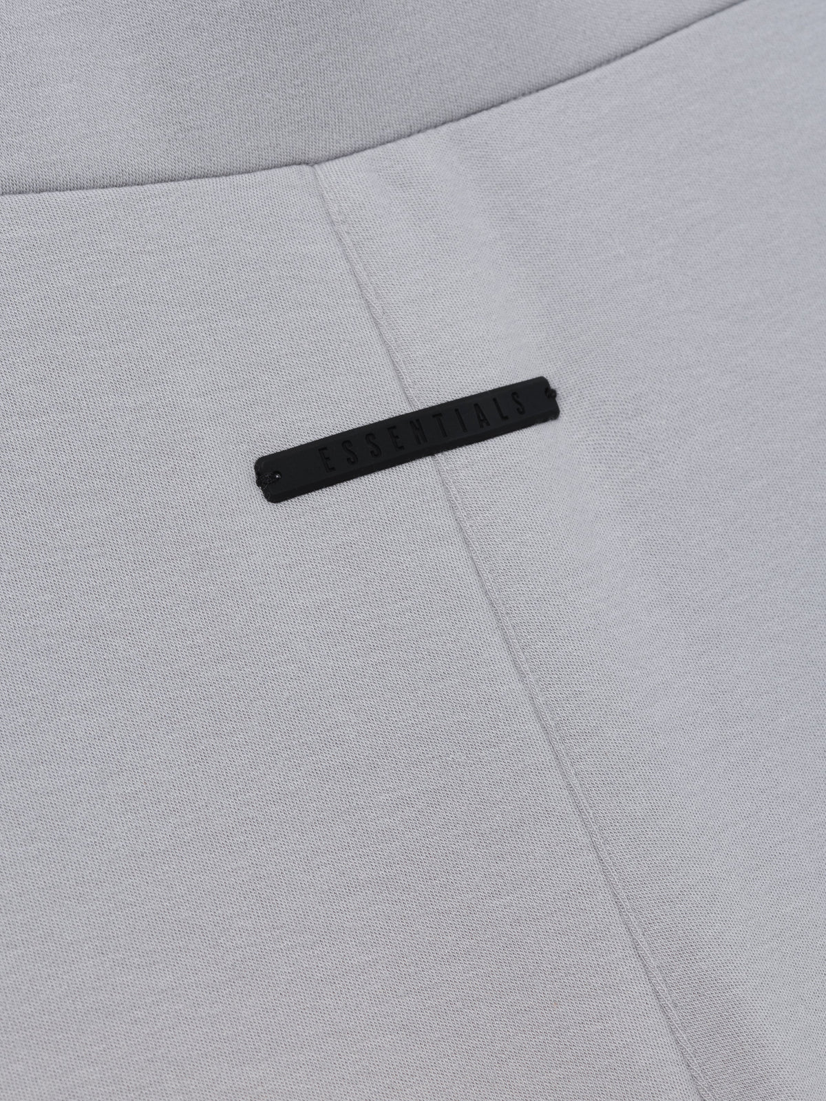 Womens Legging in light grey closeup showing a central seam and subtle black branding detail as Bottoms
