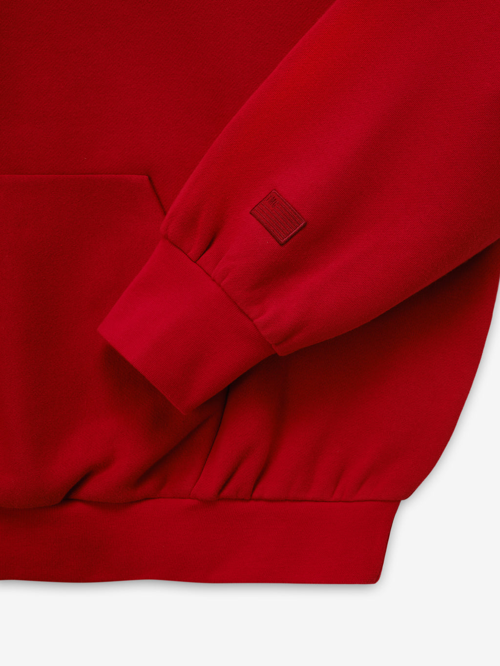 Marathon Merch Hoodie in red shown in close detail with a ribbed sleeve cuff tonal embroidered logo and soft fleece fabric as Tops
