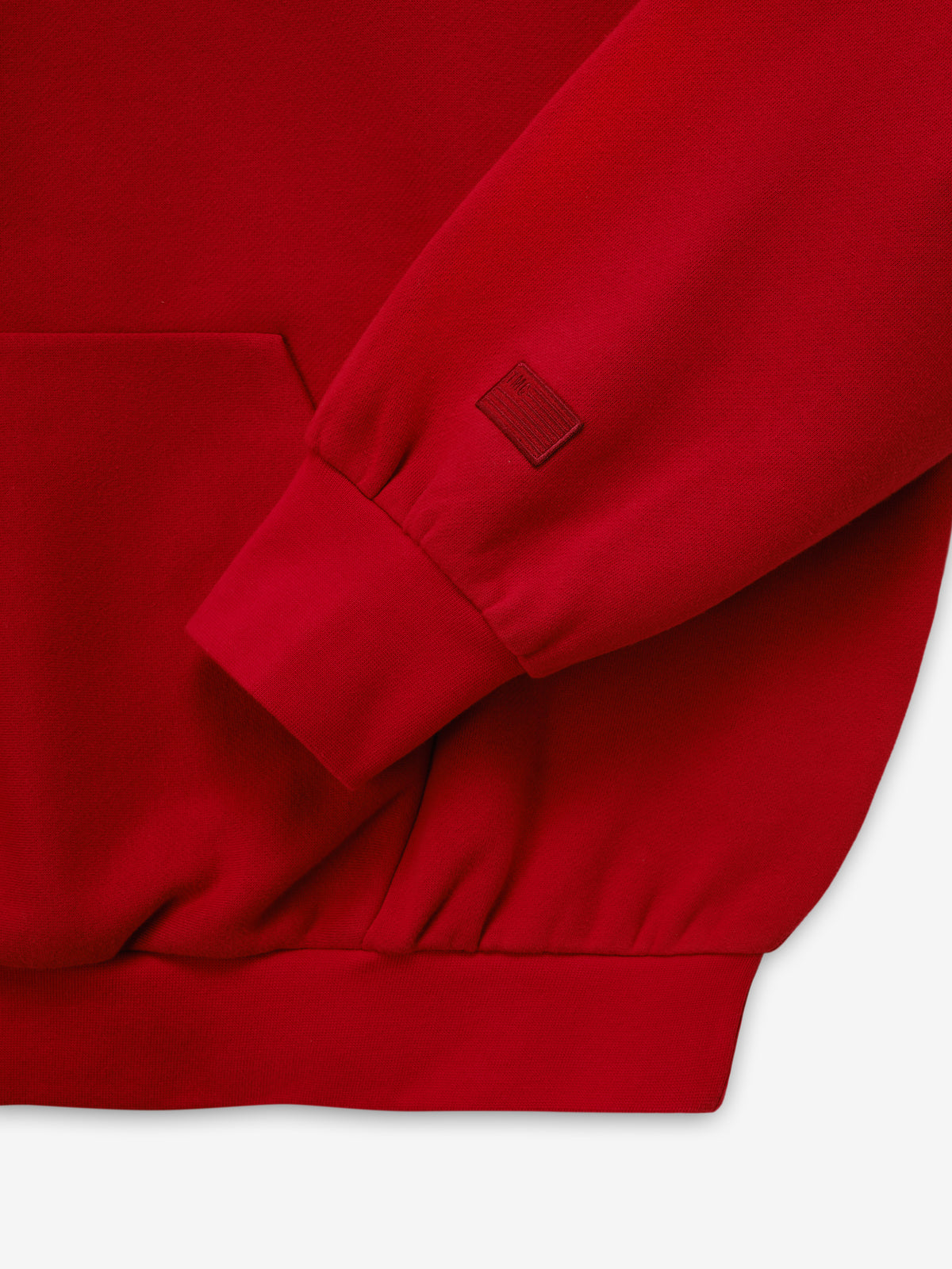 Marathon Merch Hoodie in red shown in close detail with a ribbed sleeve cuff tonal embroidered logo and soft fleece fabric as Tops