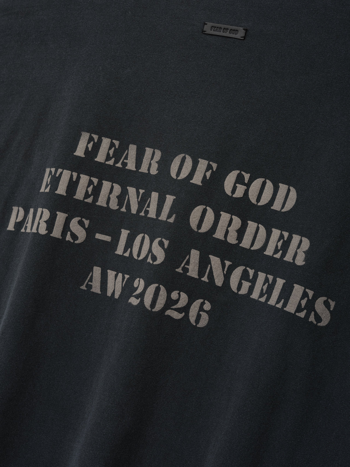 AW26 Tee in black with tonal gray Fear of God Eternal Order Paris Los Angeles AW 2026 chest lettering shown in close detail as Tops