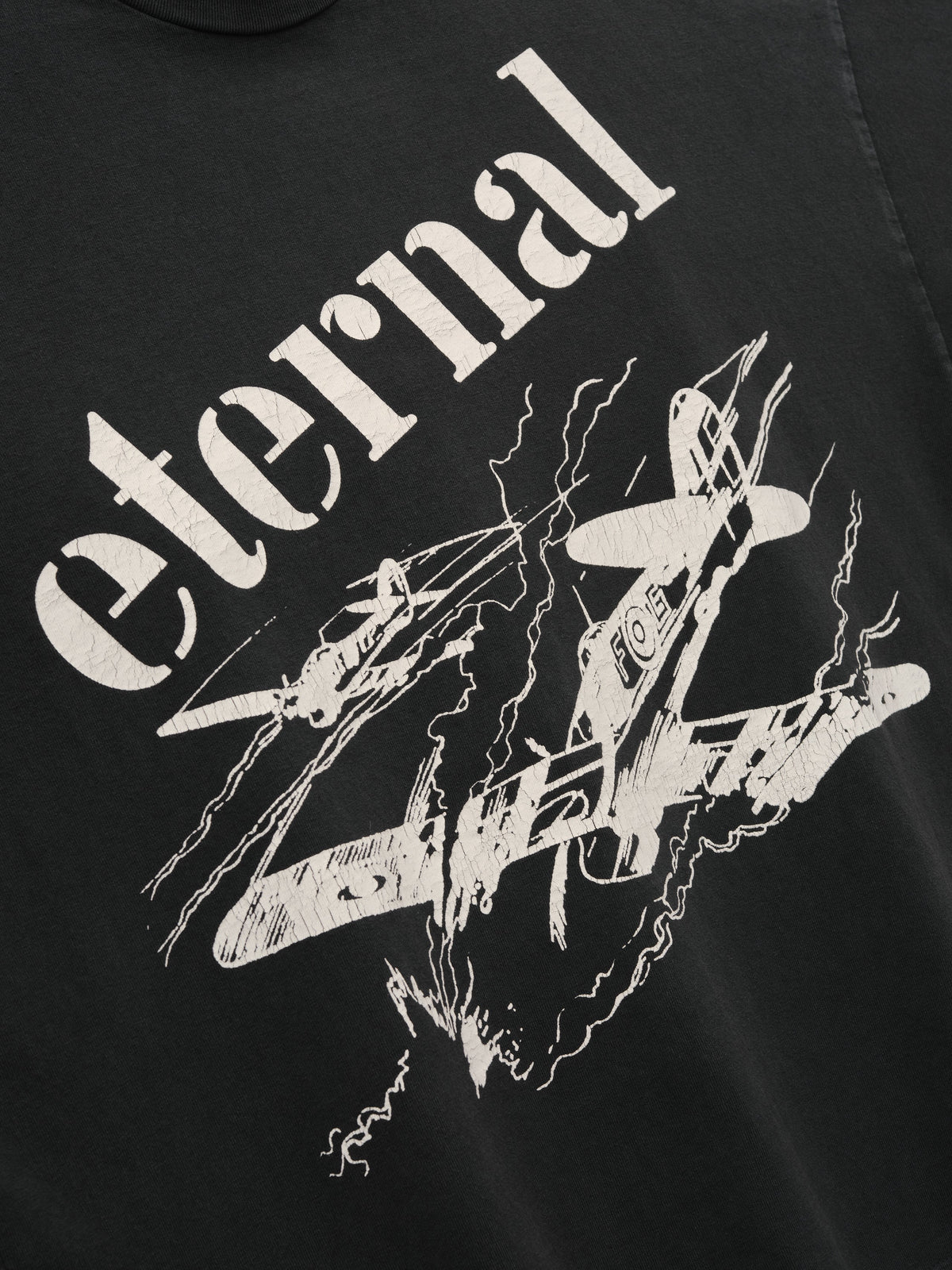 Flight Tee in black with oversized cream Eternal lettering and an abstract white illustrated chest graphic shown in close detail as Tops