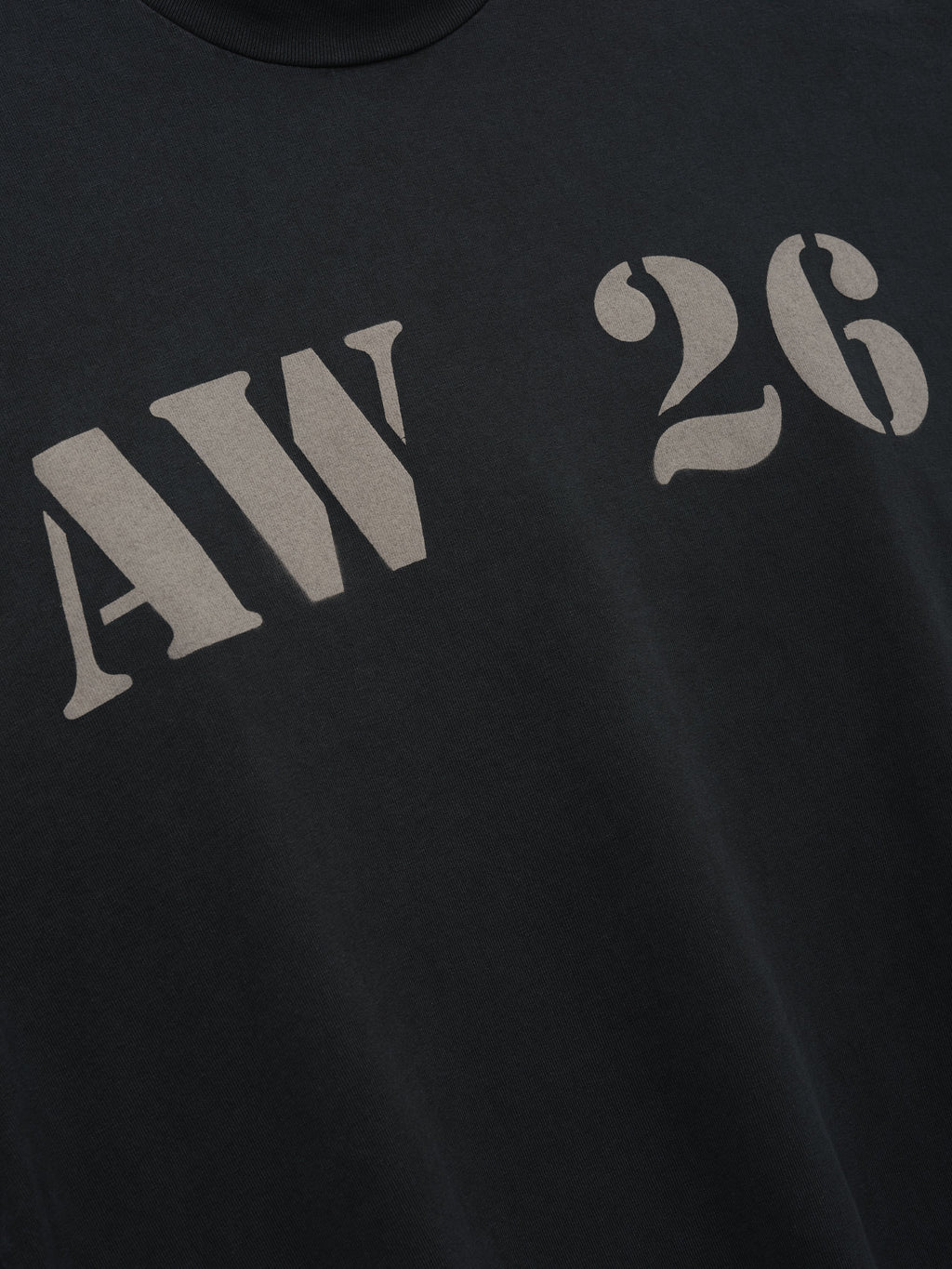 AW26 Mockneck Long Sleeve Tee in black with distressed gray AW 26 chest lettering shown in close detail as Tops