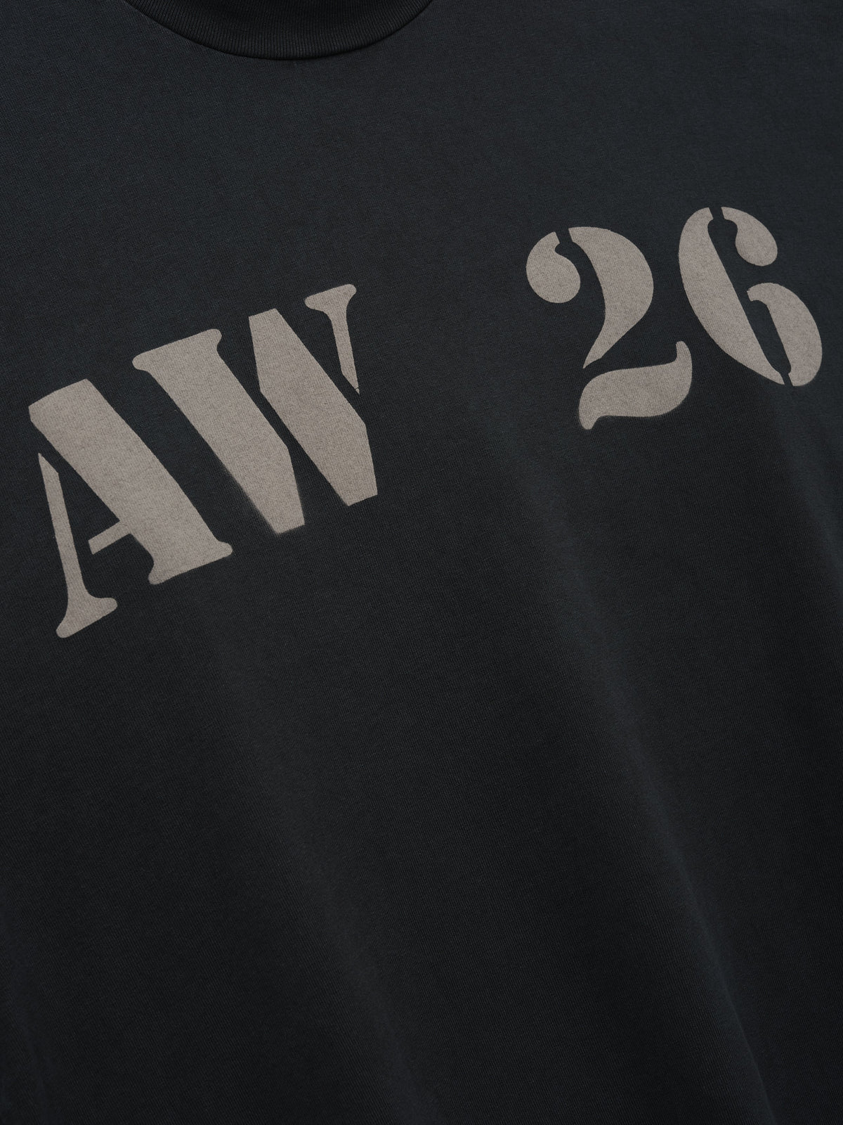 AW26 Mockneck Long Sleeve Tee in black with distressed gray AW 26 chest lettering shown in close detail as Tops