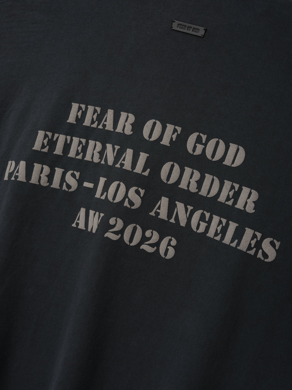 AW26 Mockneck Long Sleeve Tee in black with distressed gray Fear of God Eternal Order Paris Los Angeles AW 2026 lettering shown in close detail as Tops