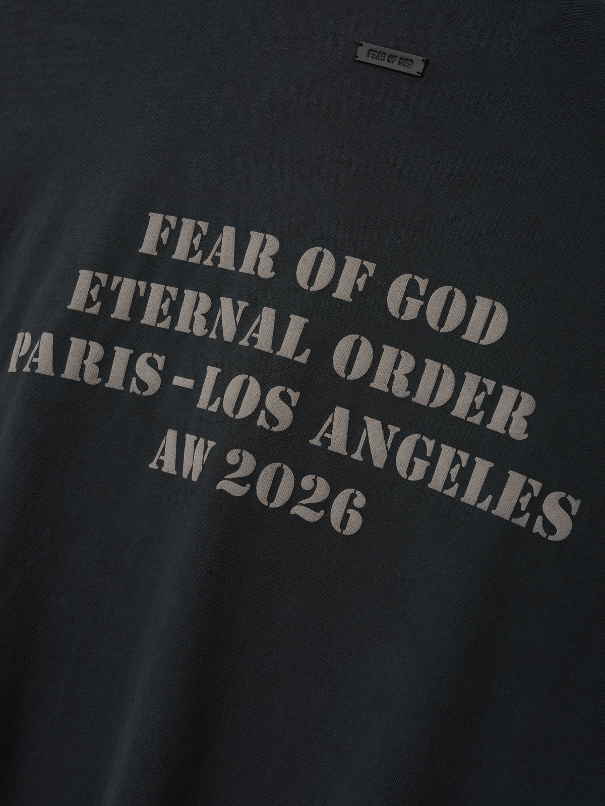 AW26 Mockneck Long Sleeve Tee in black with distressed gray Fear of God Eternal Order Paris Los Angeles AW 2026 lettering shown in close detail as Tops