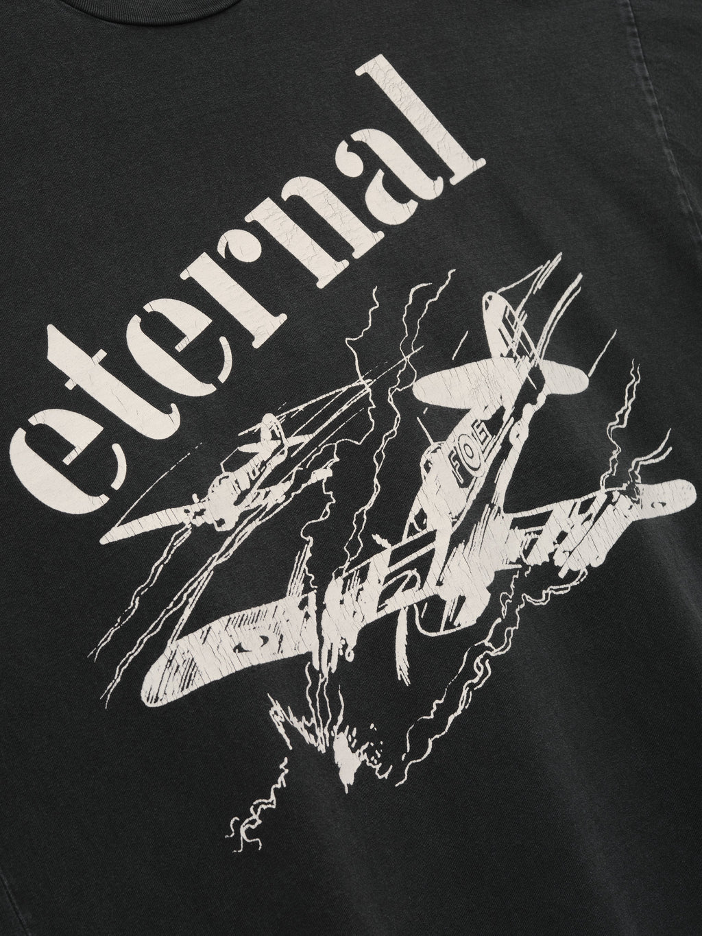 Flight Long Sleeve Tee in black with cream Eternal lettering and aircraft artwork surrounded by lightning graphics shown in close detail as Tops