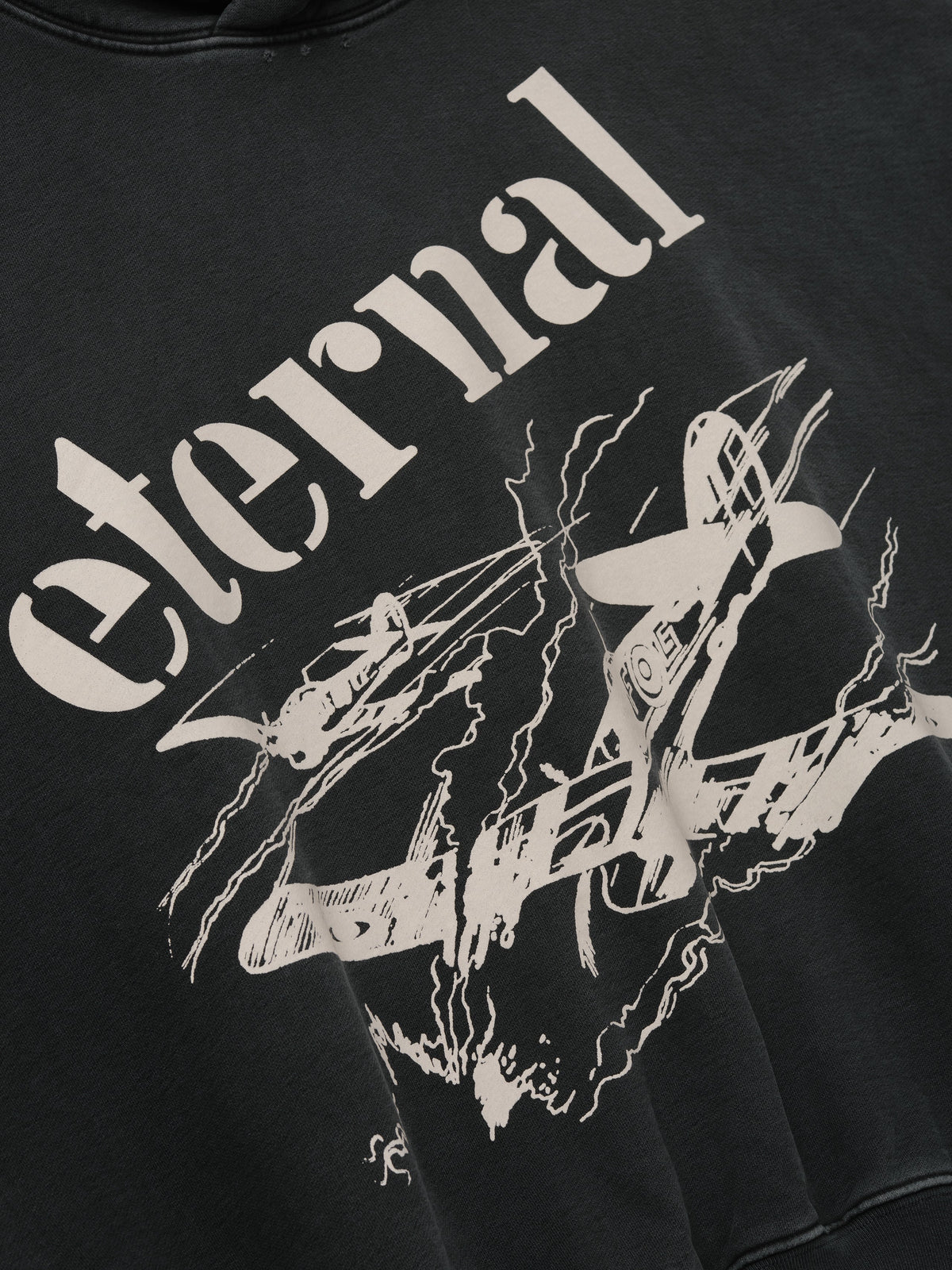 Flight Hoodie in black with oversized cream Eternal lettering and vintage aircraft artwork on the front shown in close detail as Tops