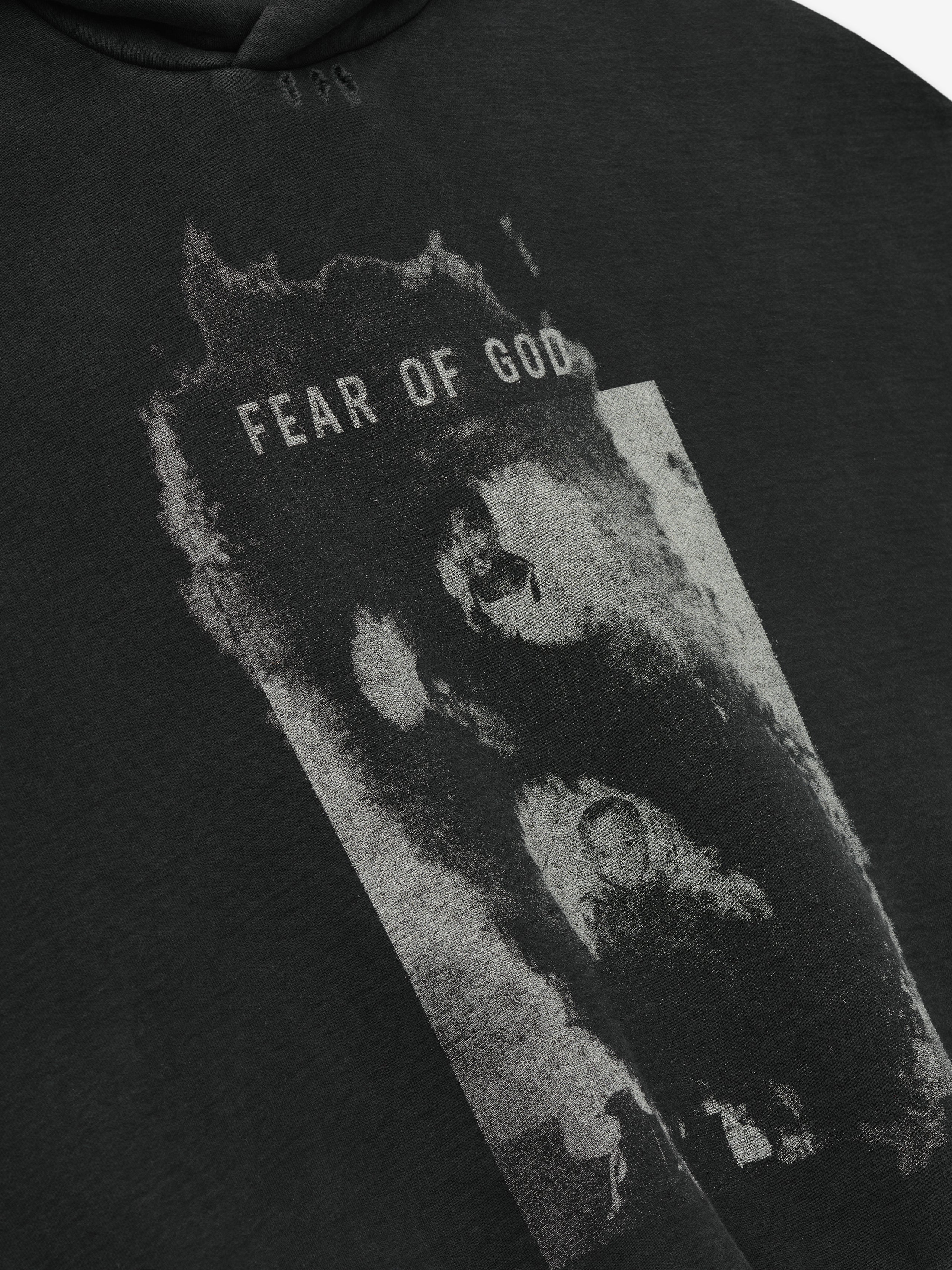 dark charcoal cotton fleece hoodie with distressed black-and-white graphic and Fear of God text on front panel