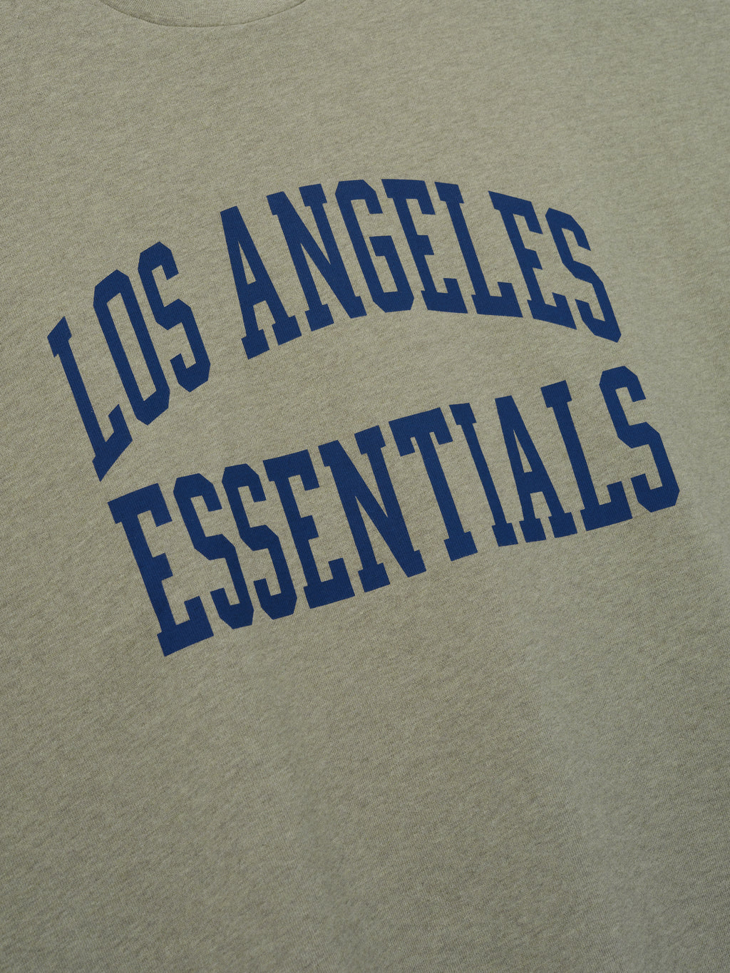 Rams Merch Tee gray fabric close up featuring bold blue Los Angeles Essentials collegiate lettering in a clean Tops product detail view