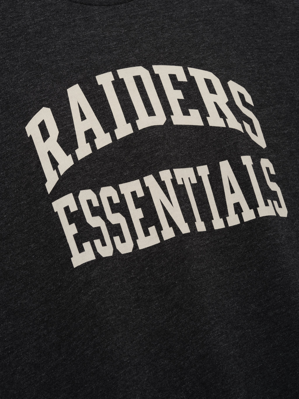 Raiders Merch Tee charcoal fabric close up with bold white Raiders Essentials collegiate lettering in a clean Tops product detail view