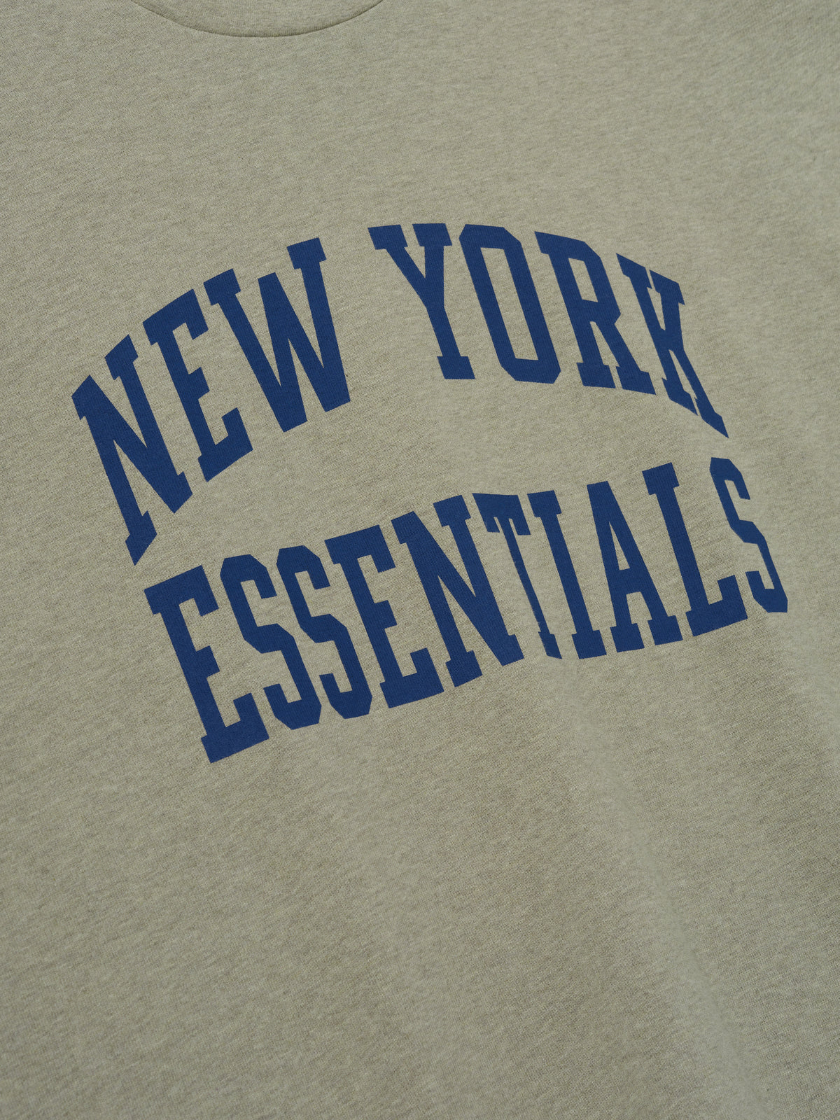 Giants Merch Tee olive gray fabric close up featuring blue New York Essentials collegiate lettering in a detailed Tops product view
