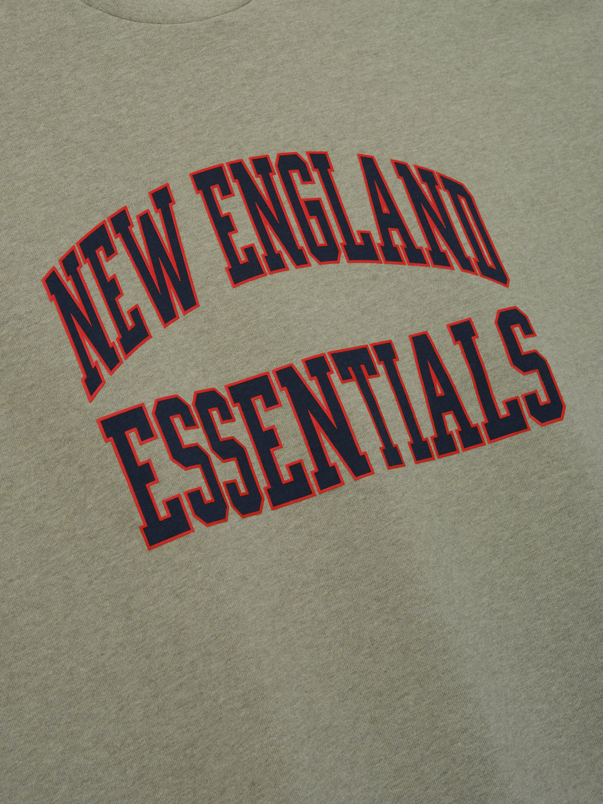 Patriots Merch Tee olive gray fabric close up featuring arched New England Essentials collegiate lettering in red and navy for a clean Tops product detail view