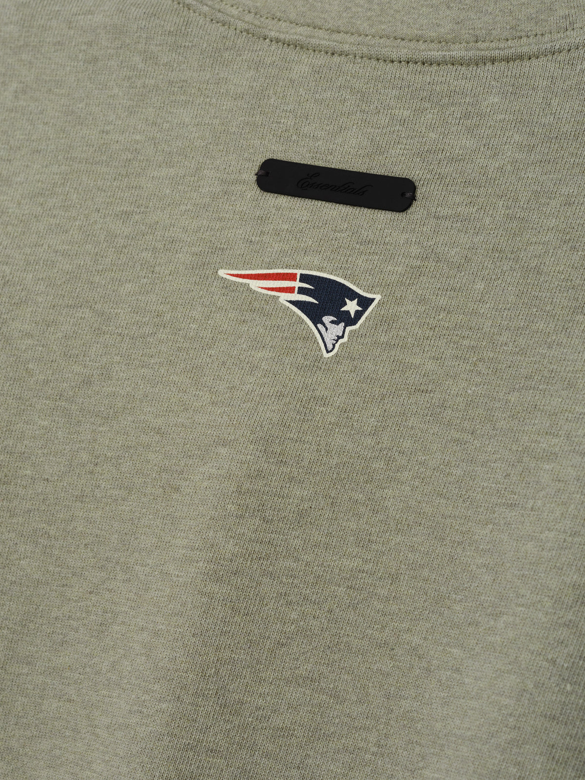 Patriots Merch Tee olive gray fabric close up with a New England Patriots logo and black chest label in a detailed Tops product view