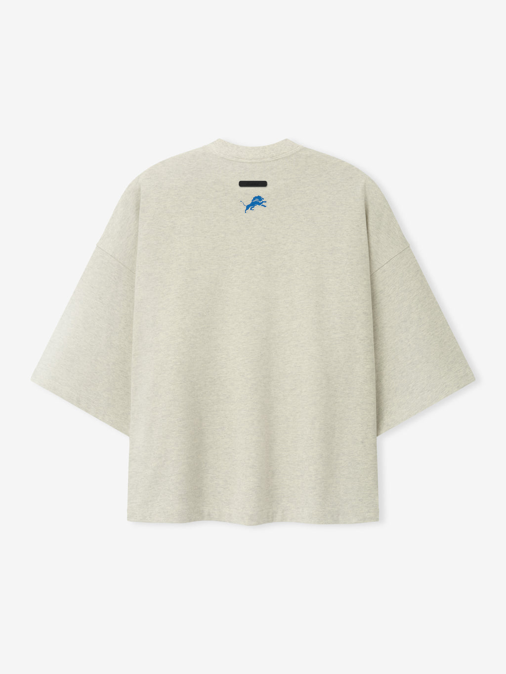 Lions Merch Tee cream oversized short sleeve shirt featuring a small blue lion emblem and black chest label displayed against a light background in a clean Tops view