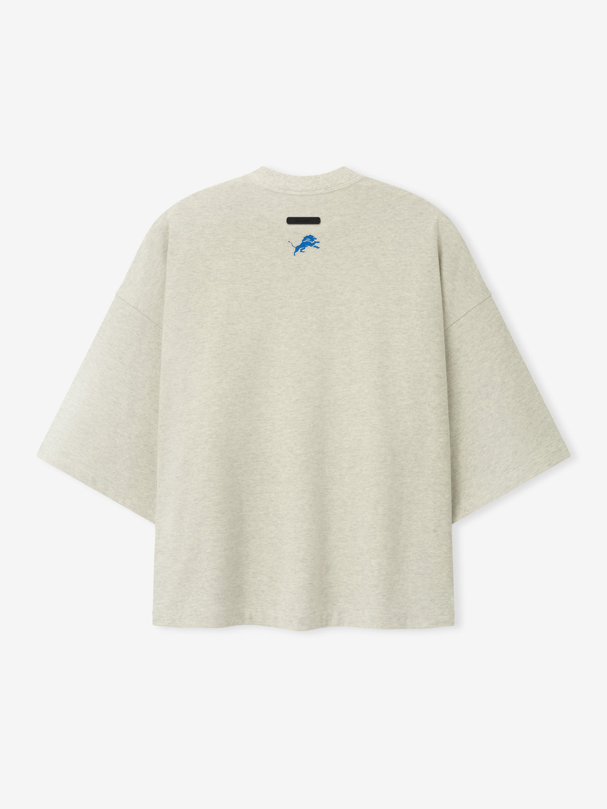 Lions Merch Tee cream oversized short sleeve shirt featuring a small blue lion emblem and black chest label displayed against a light background in a clean Tops view