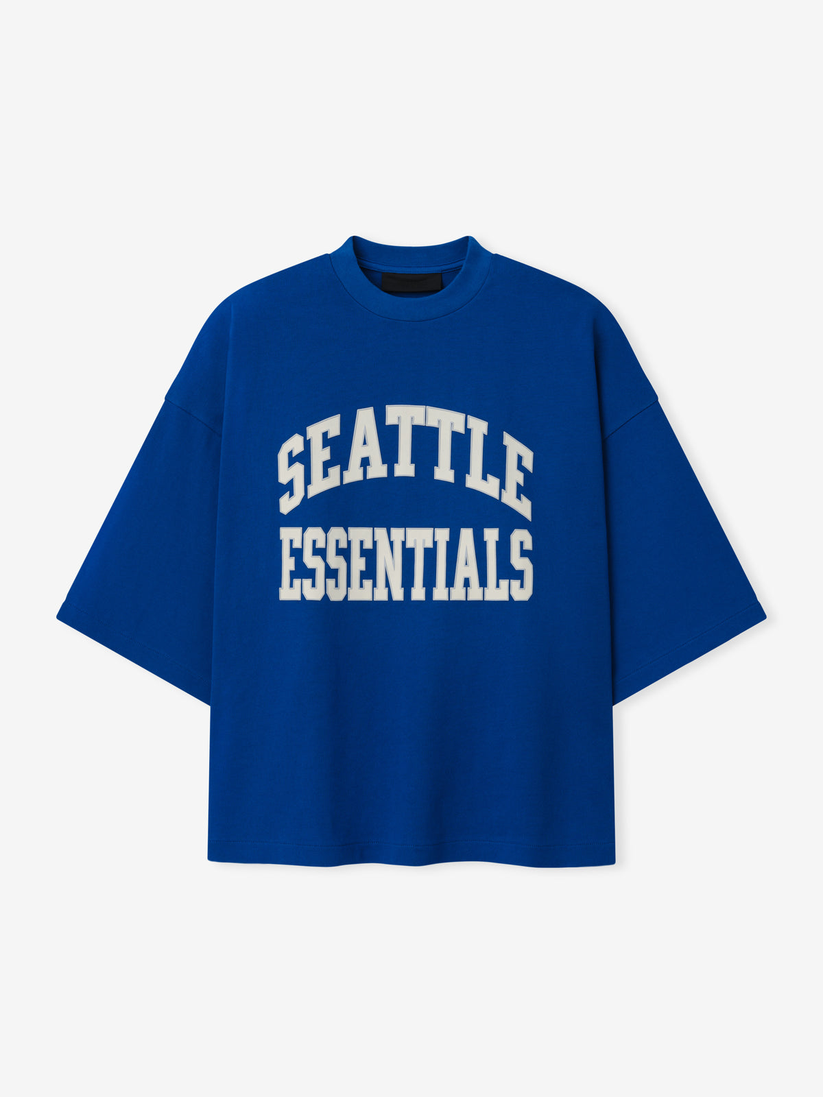 Seahawks Merch Tee blue oversized short sleeve shirt featuring bold white Seattle Essentials collegiate lettering displayed against a light background in a clean Tops product view