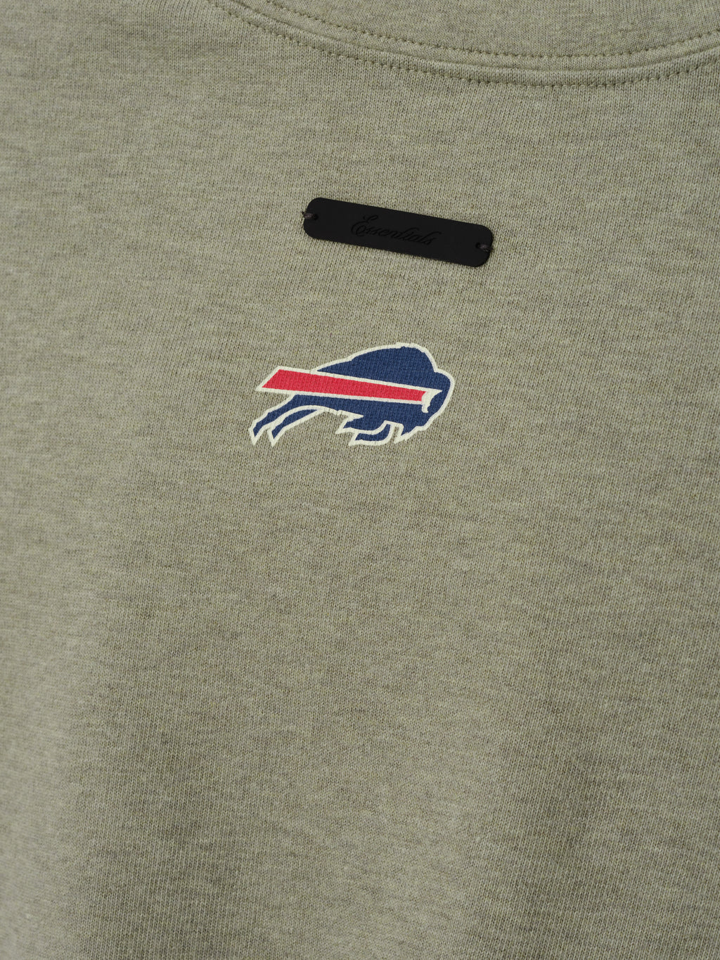 Bills Merch Tee olive green fabric close up featuring an embroidered Buffalo Bills logo and black chest label in a detailed Tops product view