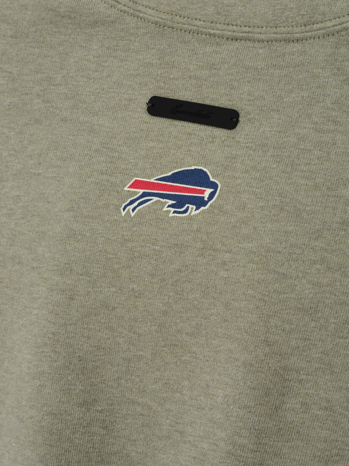 Bills Merch Tee olive green fabric close up featuring an embroidered Buffalo Bills logo and black chest label in a detailed Tops product view