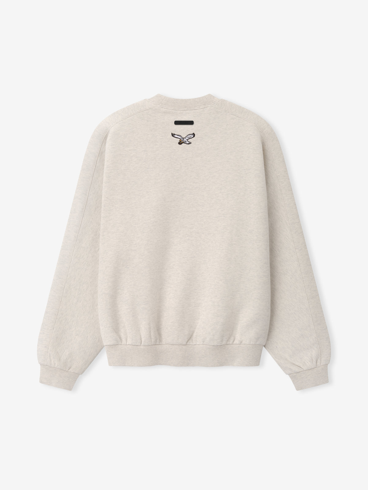 Eagles 90s Relaxed Crewneck cream sweatshirt with small Philadelphia Eagles logo and ribbed cuffs shown in a clean Tops product view