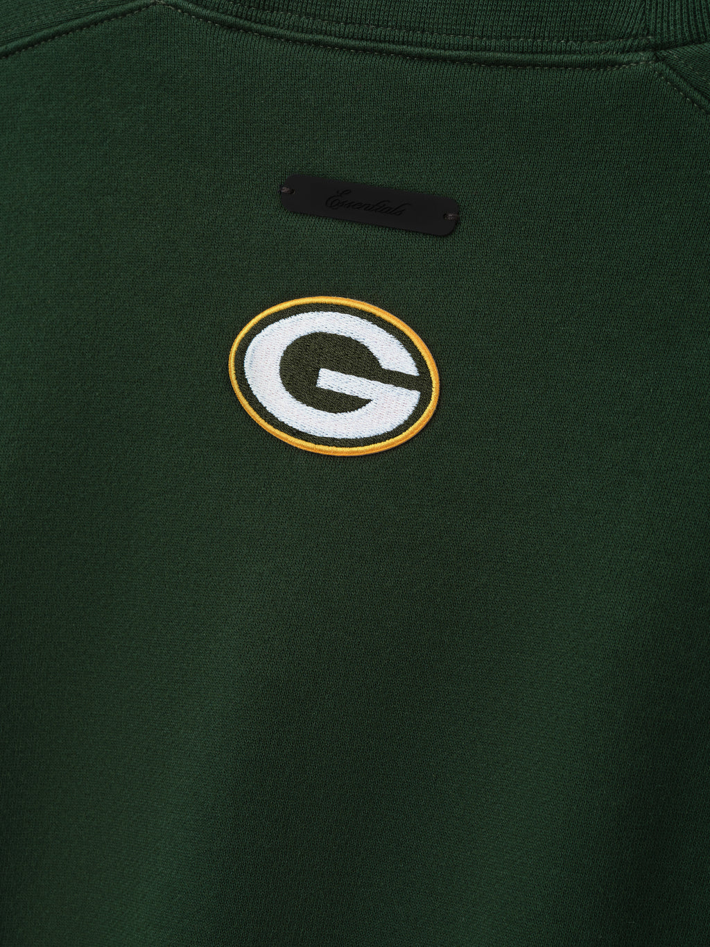 Packers 90s Relaxed Crewneck dark green sweatshirt close up featuring embroidered Green Bay Packers G logo and black chest label shown as a Tops product detail