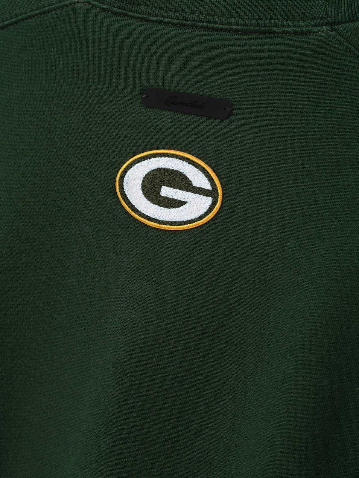 Packers 90s Relaxed Crewneck dark green sweatshirt close up featuring embroidered Green Bay Packers G logo and black chest label shown as a Tops product detail