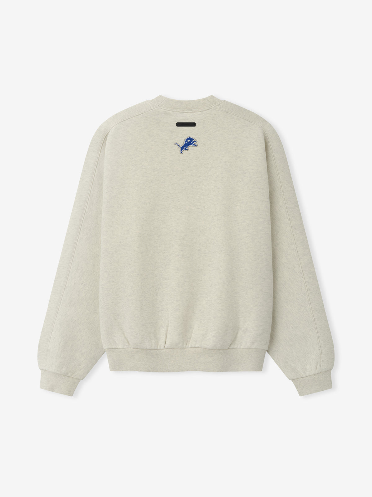 Lions 90s Relaxed Crewneck cream sweatshirt with small blue Detroit Lions logo black chest label and ribbed cuffs shown as a Tops product view