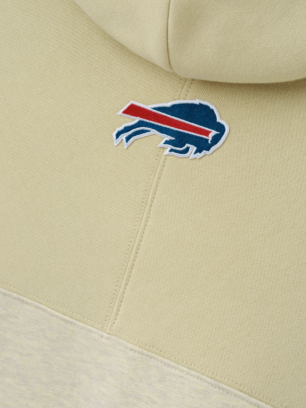 Bills 90s Relaxed Hoodie close up with embroidered Buffalo Bills charging buffalo logo on cream fleece and stitched hood seam as a Tops product detail