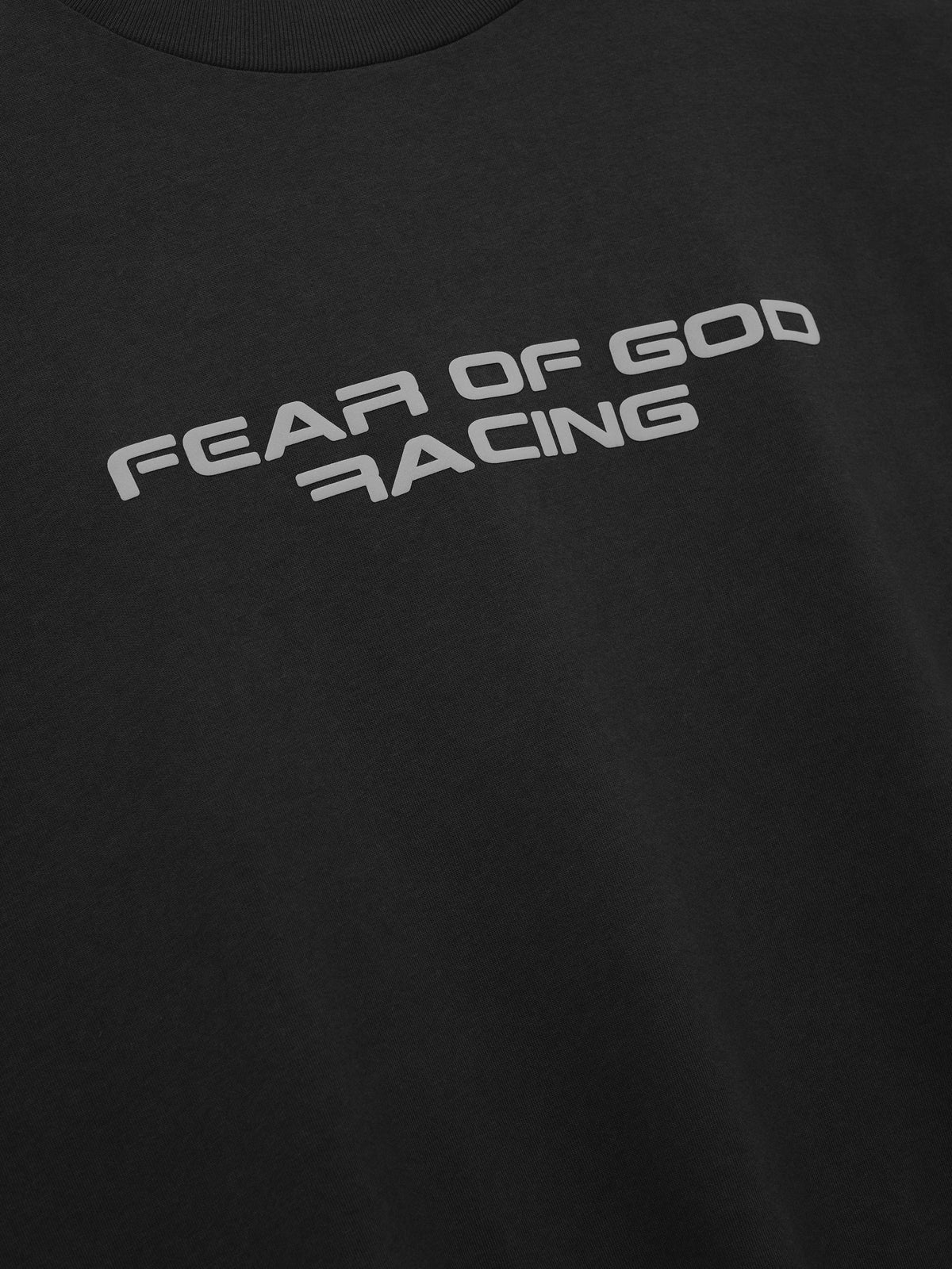 Panelled Modern Tee in black featuring a gray Fear of God Racing chest graphic shown in close detail as Tops