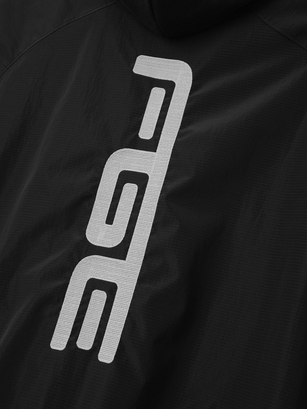 Ripstop Moto Half Zip Jacket in black featuring a close-up of the bold white vertical logo on textured ripstop fabric as Outerwear