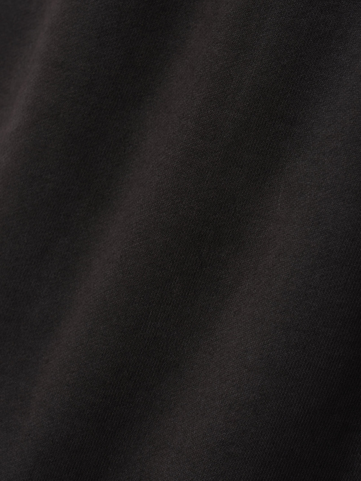 Engineered Sweatpants in black closeup revealing the fine woven fabric texture and subtle tonal surface variation for a refined finish as Bottoms