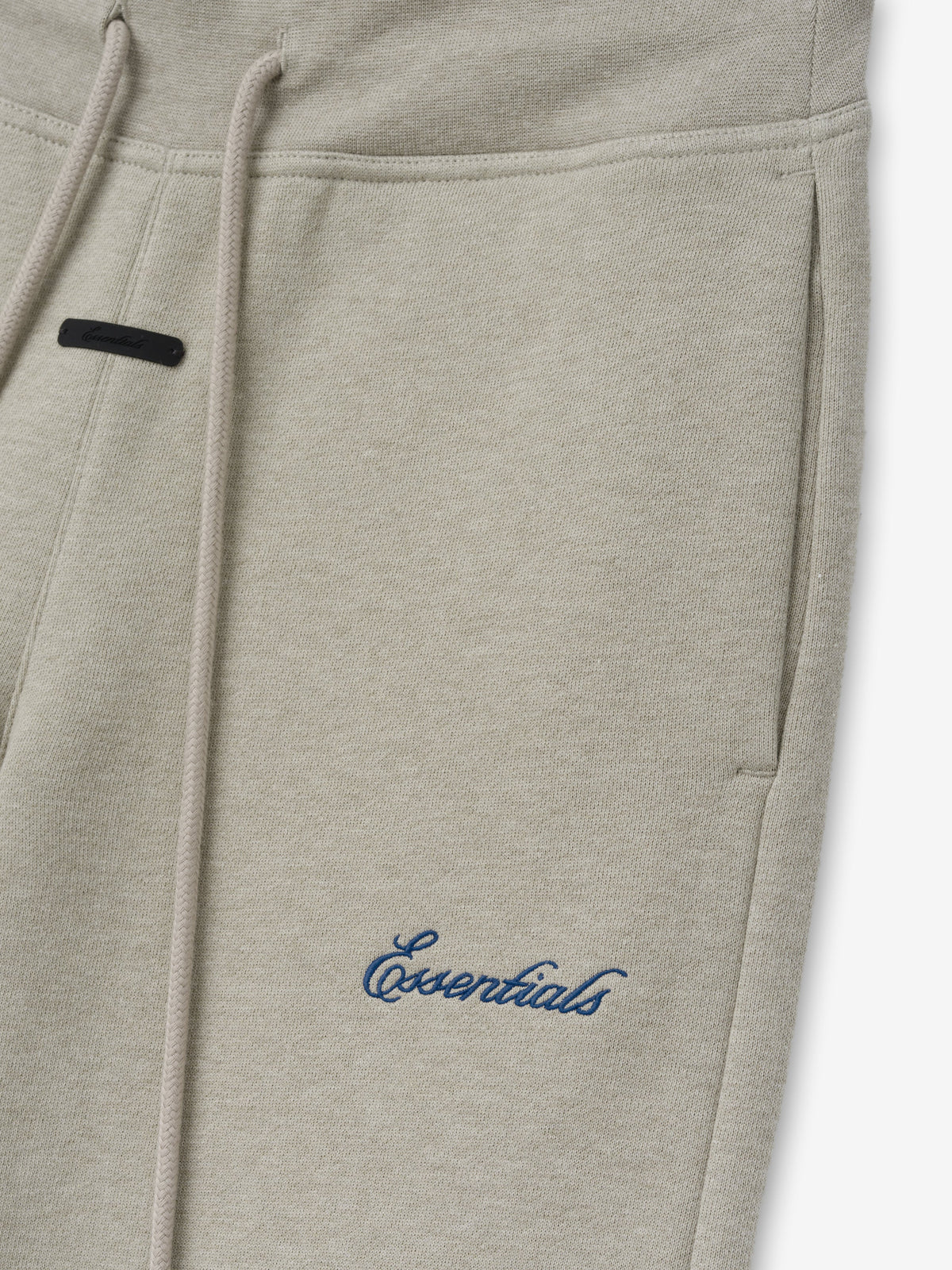 Womens Low Rise Sweatpant in heather beige with drawstring waist slanted side pocket and embroidered Essentials logo shown in close up as Bottoms