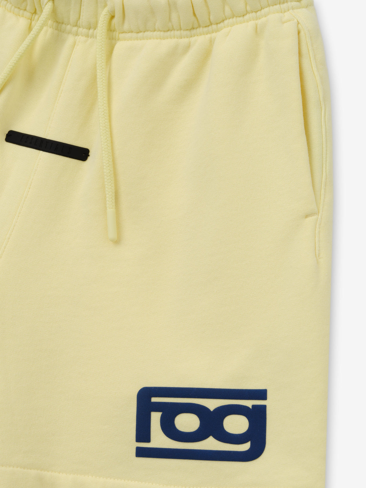 Kids Classic Short in pale yellow shown in close detail with elastic drawstring waistband side pocket black trim and blue logo patch as Bottoms