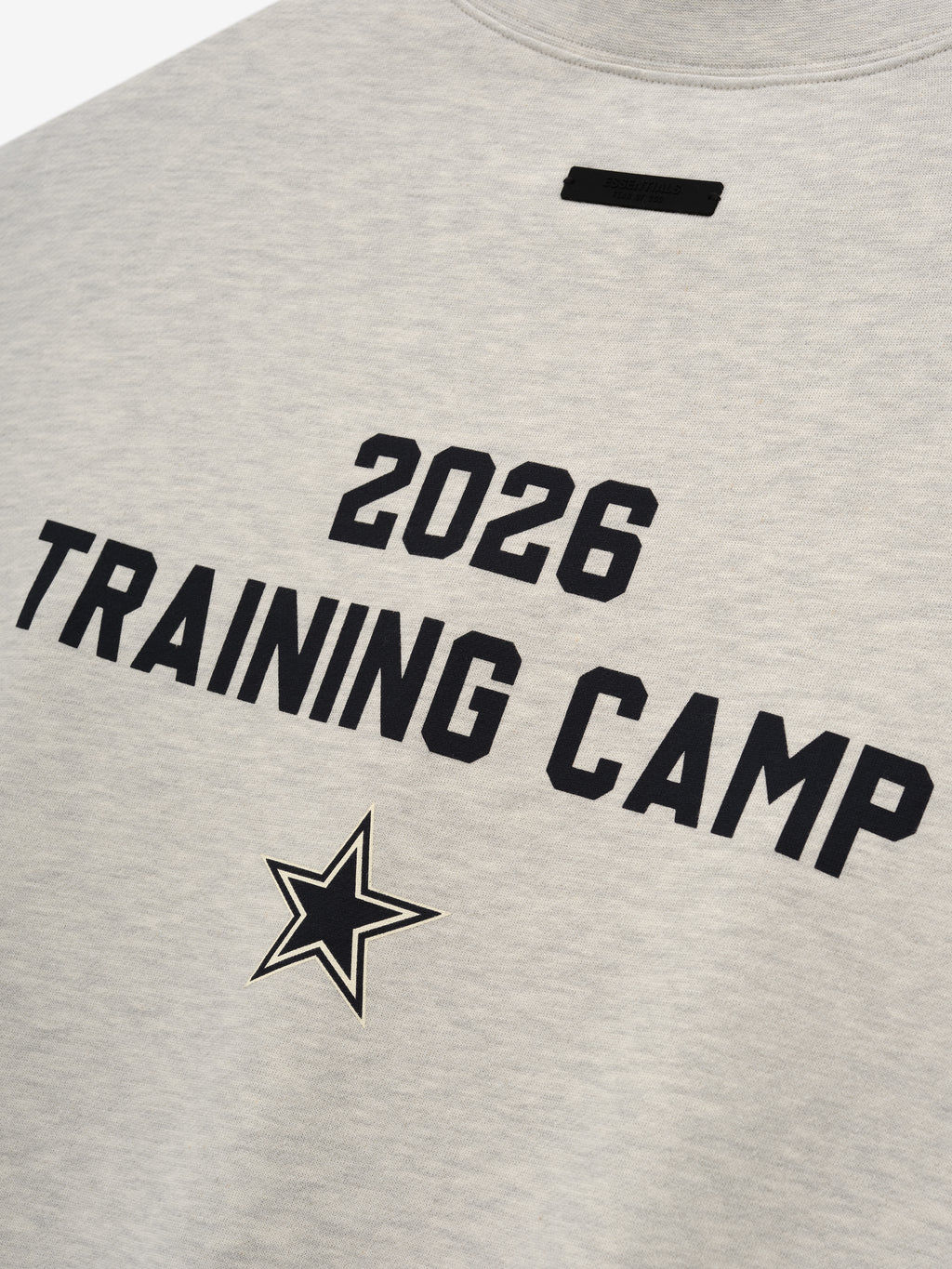 Dallas Cowboys Training Camp Crewneck Boxy Fit in light heather fabric featuring bold black "2026 Training Camp" text and a star emblem on the back of a casual top.