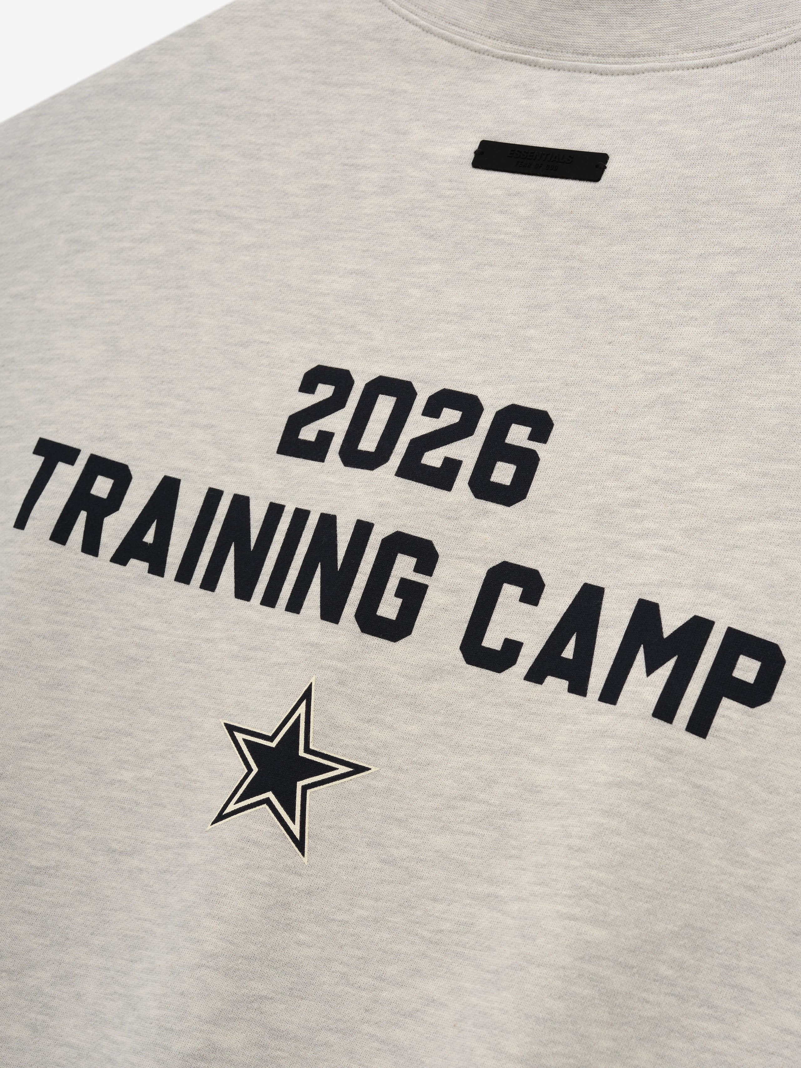 Dallas Cowboys Training Camp Crewneck Boxy Fit in light heather fabric featuring bold black "2026 Training Camp" text and a star emblem on the back of a casual top.