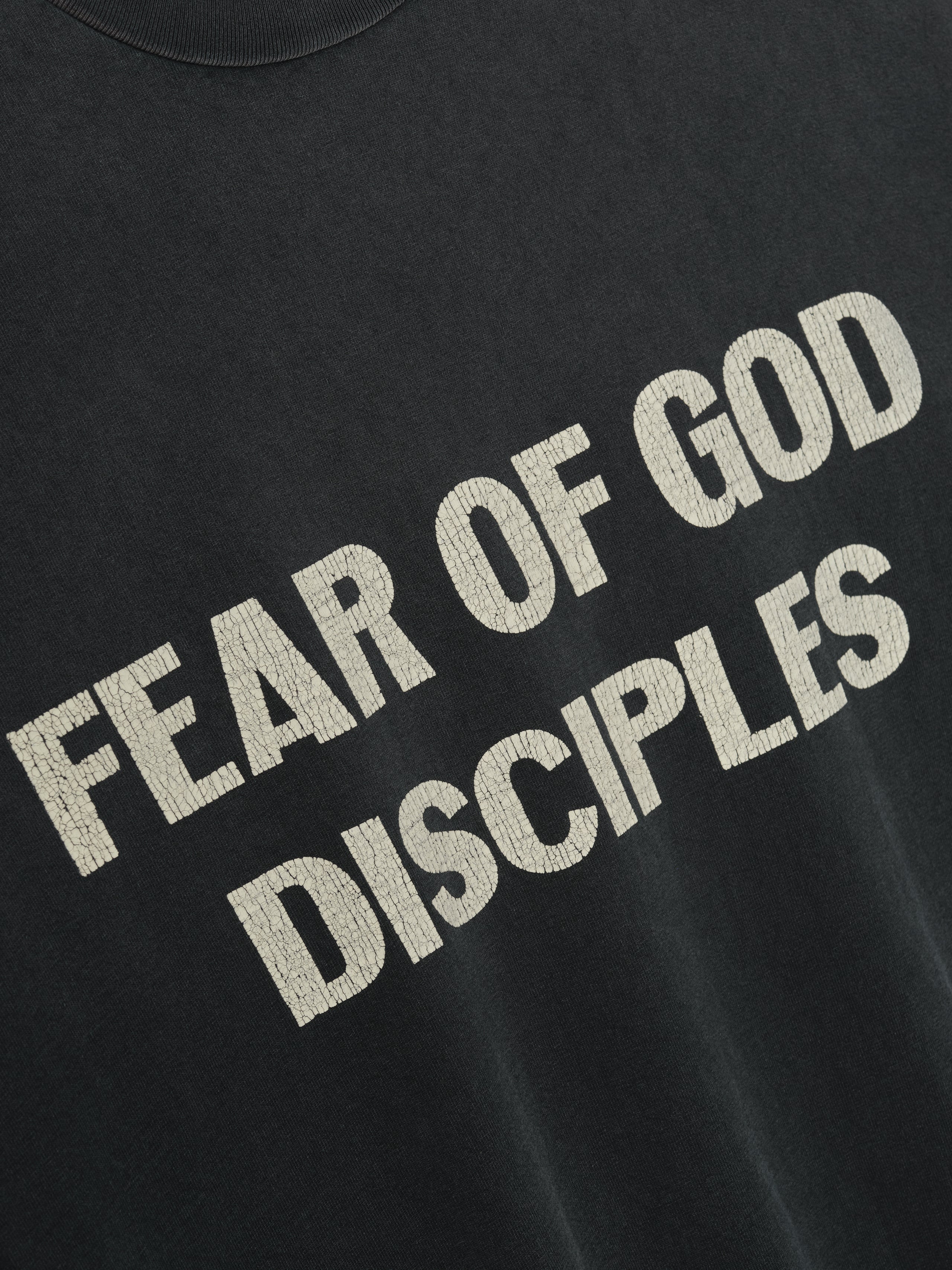 Disciple Relaxed Long Sleeve Tee in black featuring bold textured cream “FEAR OF GOD DISCIPLES” text across the chest, crafted from soft cotton for stylish casual tops wear.