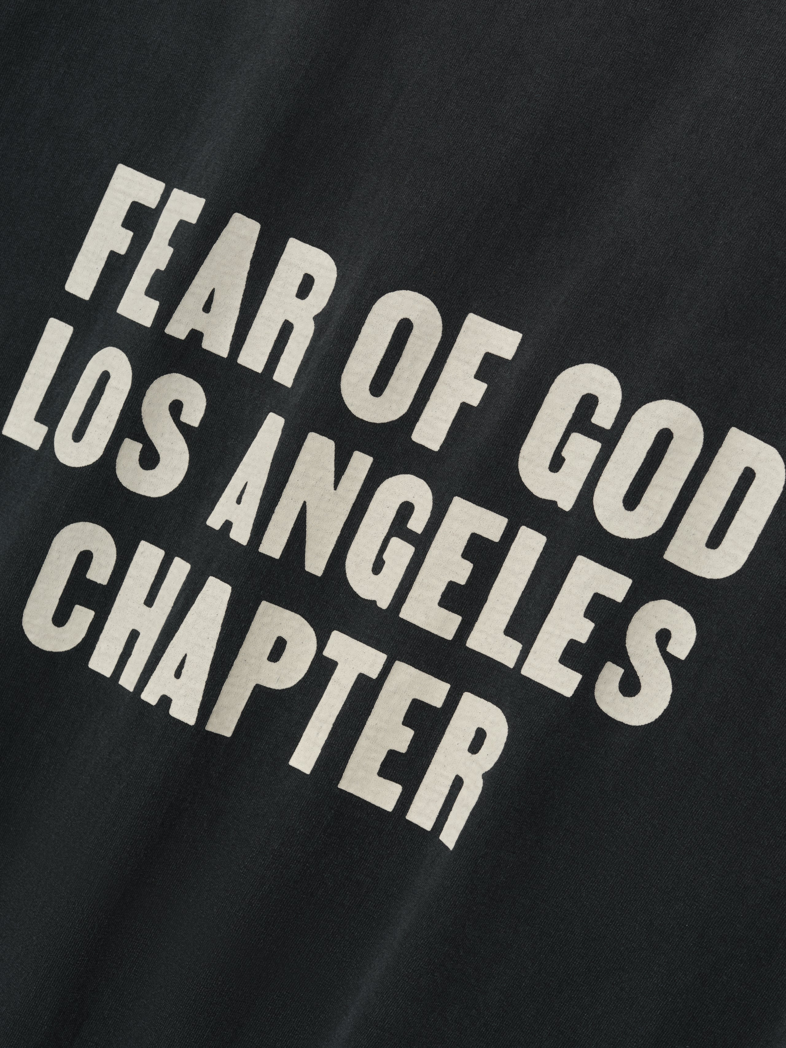 Disciple Relaxed Long Sleeve Tee in black showcasing bold cream “FEAR OF GOD LOS ANGELES CHAPTER” text printed in large letters, crafted from soft cotton for casual tops wear.