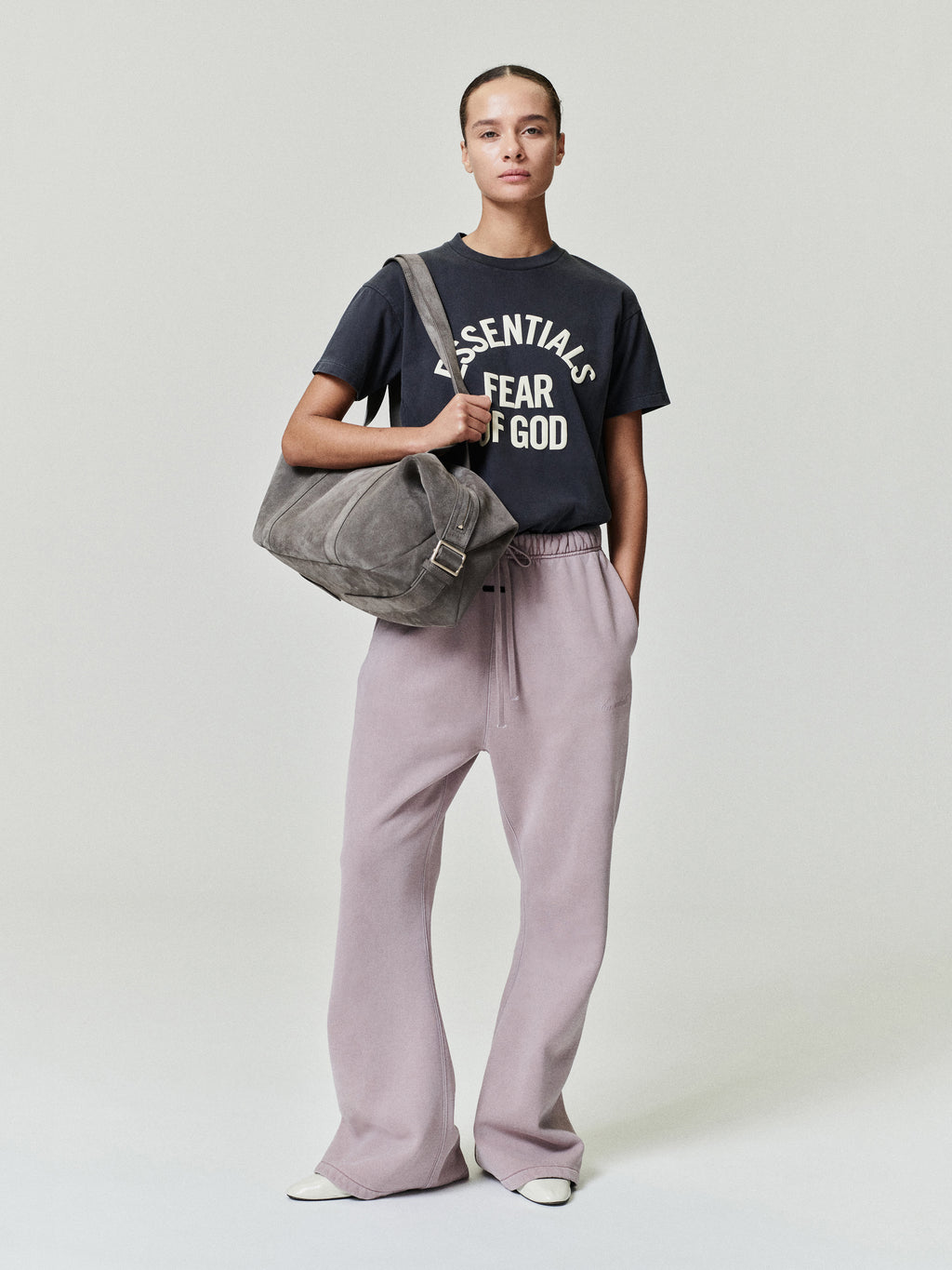 woman wearing relaxed fit flare sweatpants in muted mauve with elastic waistband and front pockets